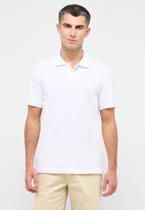 Camisa polo de algodón blanca con mangas cortas, una tapeta de tres botones y un sutil logo de la marca en el pecho. Textura suave y corte clásico.