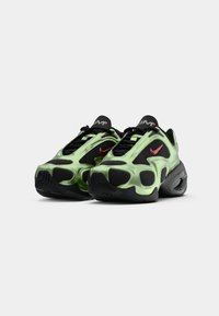 Green and black sneakers with mesh and synthetic material, featuring a textured design, visible air unit, and red Nike swoosh logo.
