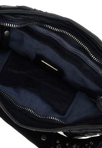 Interno di borsa in pelle nera con scomparti con cerniera. Fodera in tessuto a righe blu. Cerniera e dettagli metallici. Texture morbida.