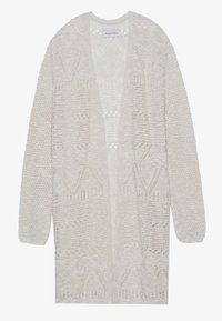 Svetr s otevřeným pletením v světle béžové barvě. Má texturovaný vzor s geometrickými vzory. Dlouhé rukávy a uvolněný střih.