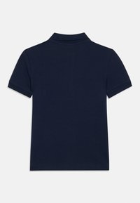 Mornarska polo majica s kratkimi rokavi, klasičnim ovratnikom in strukturirano tkanino. Na hrbtni strani ni vidnih logotipov ali vzorcev.