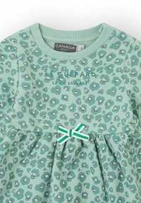 Vestido verde menta con estampado de leopardo, escote acanalado, cintura fruncida y un lazo decorativo de rayas en verde y blanco.