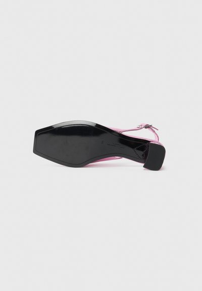 Chaussure slingback rose avec un embout carré, semelle noire et talon bloc de hauteur intermédiaire, vue par le dessous.