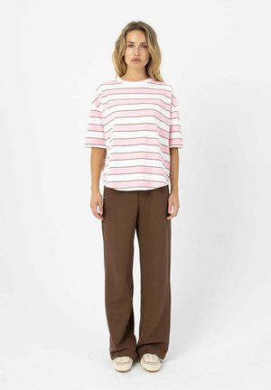Woman stands facing forward wearing a pink and white striped short-sleeve shirt, brown wide-leg pants, and beige sneakers.