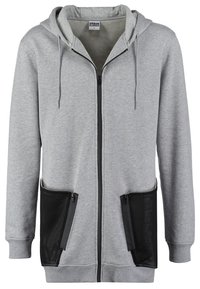 Felpa grigia con zip realizzata in tessuto morbido, dotata di cappuccio, due tasche con zip in rete nera e polsini e orlo a costine.