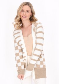Cardigan a righe beige e bianche con apertura davanti, polsini e orlo a coste. Realizzato in morbido materiale a maglia, presenta una vestibilità comoda.