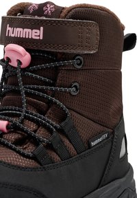 Brune vandrestøvler med hummelTEX materiale, pink detaljer, sort robust sål, struktureret stof og snørebåndslukning med krog.