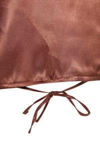 Tissu en satin marron avec un nœud noué au bord inférieur, présentant une texture lisse et un léger éclat.