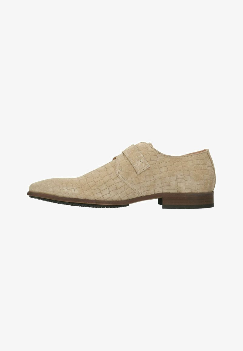 Beige leren dress shoe met een gestructureerd krokodillenpatroon, puntige neus en verstelbare band. Lage, bruine houten hak met rubberen zool.