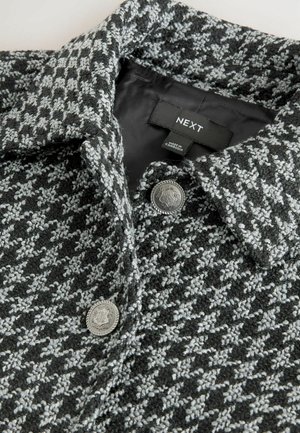 Grau- und schwarz Geweihmuster-Mantel mit Kragen, metallischen Knopfdetails und glatter Innenauskleidung. Etikett zeigt die Marke "NEXT."