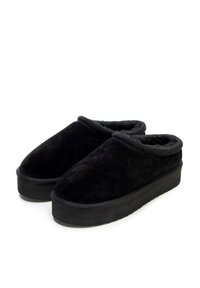 Černé semišové nazouvací boty s měkkou umělou kožešinovou podšívkou a silnou černou gumovou podrážkou. Zaoblená špička a vystouplý lem kolem otvoru.