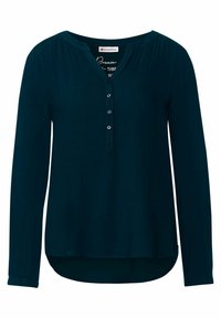Blusa teal a maniche lunghe con scollatura a V, doppio fascetto con sei bottoni e orlo curvo. Realizzata in un tessuto morbido con una leggera lucentezza.