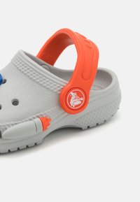 Halli Hall with orange rihm ja aktsendid, tõstetud täppide ja koomiksilaadse disainiga. Silmapaistev brändimine rihmal.
