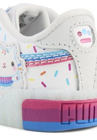 Valkoinen lenkkari, jossa on teksturoitu materiaali, esittelee sarjakuvakissan ja värikkäiden ripotteiden kuvion. Teksturoitu pastellisävyinen pohja, jossa on vaaleanpunaisia ja sinisiä yksityiskohtia.