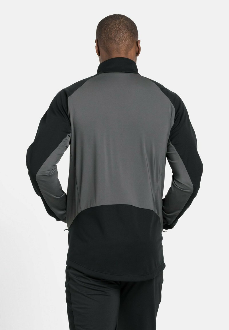 Herrenjacke aus schwarzem und grauem Stoff, mit hohem Kragen, langen Ärmeln und einer glatten Textur im Farbblockdesign.