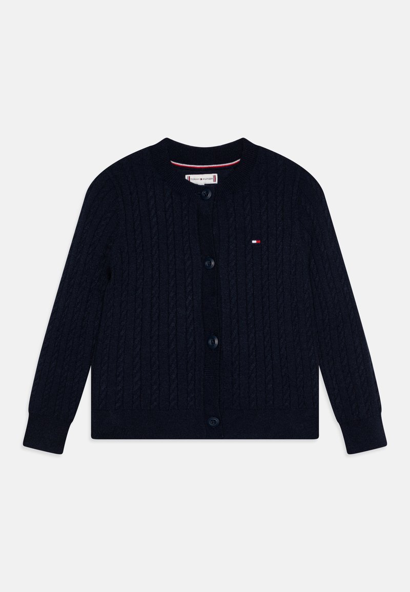 Marineblå strikket cardigan med kabelmønster, rund hals og knappestolpe. Har liten logo-patch i rødt, hvitt og blått.
