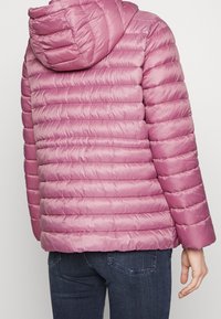 Puffig, höftlång jacka i pastellrosa, med horisontell quiltad design, huva och långa ärmar. Slät, blankt tyg.