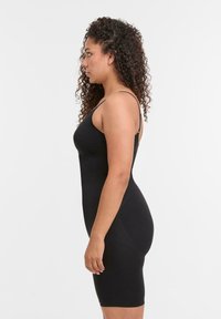 Abito nero aderente con spalline sottili, realizzato in tessuto liscio, lungo fino al ginocchio con una leggera elasticità, caratterizzato da un design elegante e minimalista.
