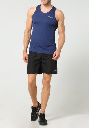 Camiseta atlética sin mangas azul marino con un patrón texturizado, combinada con pantalones cortos negros. Ambos presentan el logo de Asics en la tela.