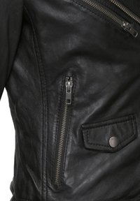 Schwarze Lederjacke mit einer Nahaufnahme von einer Reißverschlusstasche, metallischen Hardware und einer strukturierten Oberfläche mit einem Druckknopfdetail.