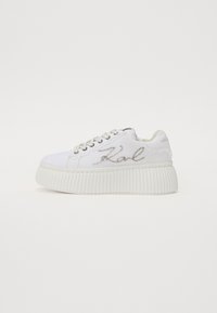 Sneakers bianchi in tela con suola piatta a righe, caratterizzati da ricamo argentato "Karl" sul lato e chiusura con lacci.
