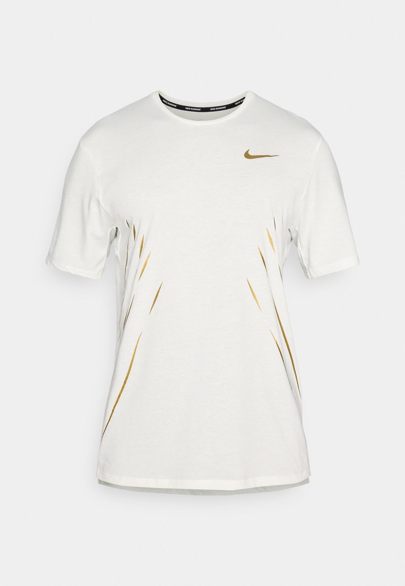 Biała koszulka z krótkim rękawem z złotymi akcentami i czarnym logo Nike na klatce piersiowej. Wykonana z teksturowanej tkaniny. Okrągły dekolt.