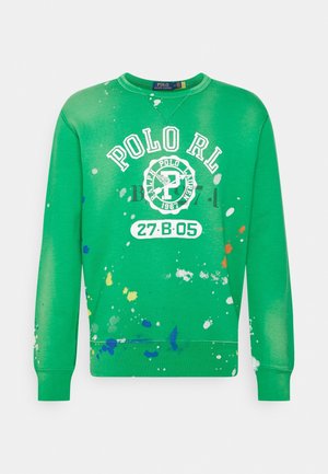 Zielona bluza typu crewneck z białym napisem „POLO RL”, logo z napisem „Ralph Lauren 1967”, numerami „27·B·05” oraz wielokolorowymi plamkami farby.