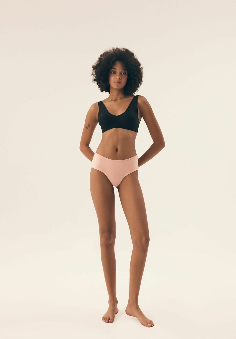 Czarny biustonosz typu bralette z okrągłym dekoltem oraz jasnoróżowe majtki z wysokim stanem. Materiał jest gładki o miękkiej fakturze, dopasowany do ciała.