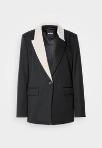 Black tailored blazer with a contrasting white shawl collar, single button closure, and two front pockets. Smooth fabric texture.