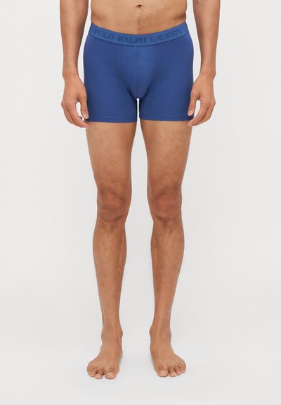 Blaue Herren-Boxershorts aus weichem Stoff. Mit einem logobestempelten Bund und einer figurbetonten Passform. Glatte Textur, gerades Bein-Design.