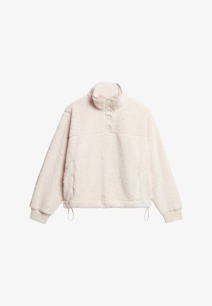 Sudadera de forro polar en color crema con cuello alto, botones de presión y bolsillos laterales. Incluye puños elásticos y dobladillo ajustable con cordón.