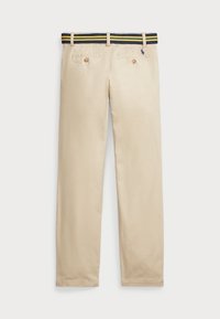 Pantalons beiges avec des poches arrière à boutons et une ceinture rayée bleue, jaune et verte, vus de dos.