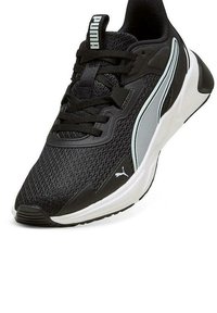 Zapato deportivo negro hecho de malla y material sintético. Presenta una suela blanca, el logotipo de PUMA y un diseño elegante y aerodinámico con acentos en contraste.