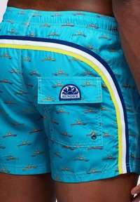 Pantaloni da bagno aqua con un motivo ripetuto di sole e tavole da surf, dotati di tasca laterale e accenti a strisce contrastanti in blu e giallo.