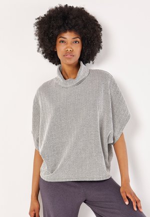 Grijze en witte houndstooth oversized top met een cowl neck, korte mouwen en een zachte textuur, gecombineerd met donkergrijze onderkleding.