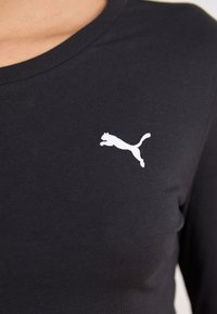 Camisa de carnaval de algodão preta de mangas longas com o logótipo branco da Puma no lado esquerdo do peito. Textura suave com um clássico decote redondo.