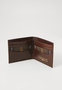 Brown leather bi-fold wallet open showing card slots with tartan fabric lining and gold brand logo on right side.
