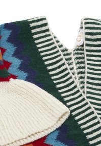 Pulover tricotat cu decolteu în V, bază verde cu modele zigzag multicolore, accente crem și dungi albe contrastante pe margini.