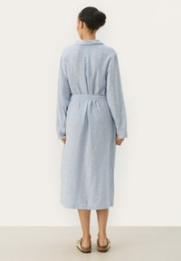 Vestito lungo a strisce blu chiaro e bianche con colletto, maniche lunghe, cintura da annodare in vita e vestibilità rilassata.
