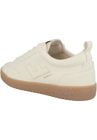 Bílé kožené tenisky s strukturovaným povrchem, světle hnědou gumovou podrážkou a vyvýšeným logem. Obsahují kulaté tkaničky a zadní poutko.