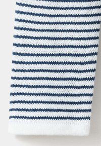 Tissu tricoté blanc et bleu marine avec fines rayures horizontales, montrant une texture détaillée et un motif de couture.