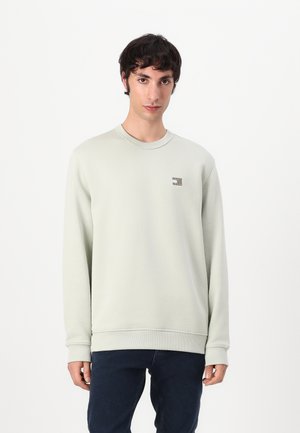 Lysegrøn sweatshirt lavet af blødt stof, med rund halsudskæring og ribbede manchetter. Viser et lille logo på venstre bryst.
