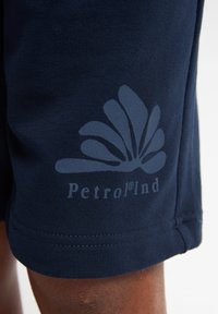 Marineblauwe shorts met een geweven stof, een logo ontwerp in een lichtere tint en zichtbare stiksels langs de zoom.