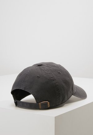 Ciemnoszara, regulowana bawełniana czapka z daszkiem leżąca na białym narożnym podłożu, widoczna od tyłu z metalową klamrą i paskiem.