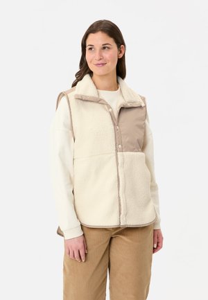 Fleece vest in crème en beige met knoopsluiting, hoge kraag en zachte textuur. Heeft zijzakken en contrasterende afwerking.