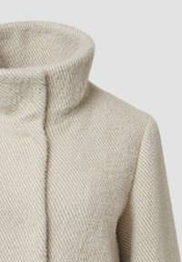 Beige wollen blendjas met een hoge kraag, met een visgraatstructuur en een schoon, minimalistisch ontwerp. Geen zichtbare sluitingen of versieringen.