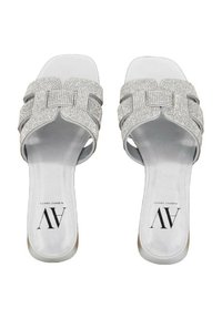 Sandali in argento con design a fascia intrecciata decorata con strass, dotati di una soletta bianca liscia e una suola piatta.