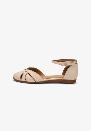 Beige platte sandaal met gesloten neus, uitgesneden zijkanten, enkelriem met gesp en lage houten zool.