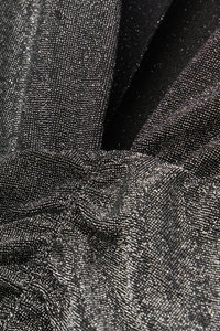 Zwart textiel met een metalen glans, voorzien van fijne glinsters en geplooide details. Het oppervlak oogt glad en reflecterend.