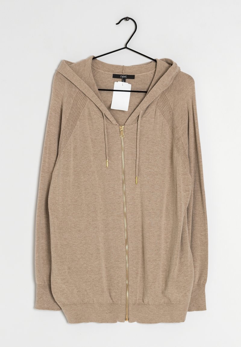 Sweat à capuche zippé marron clair avec capuche, cordons et détails côtelés sur les manches, suspendu à un cintre noir avec une étiquette de prix blanche.